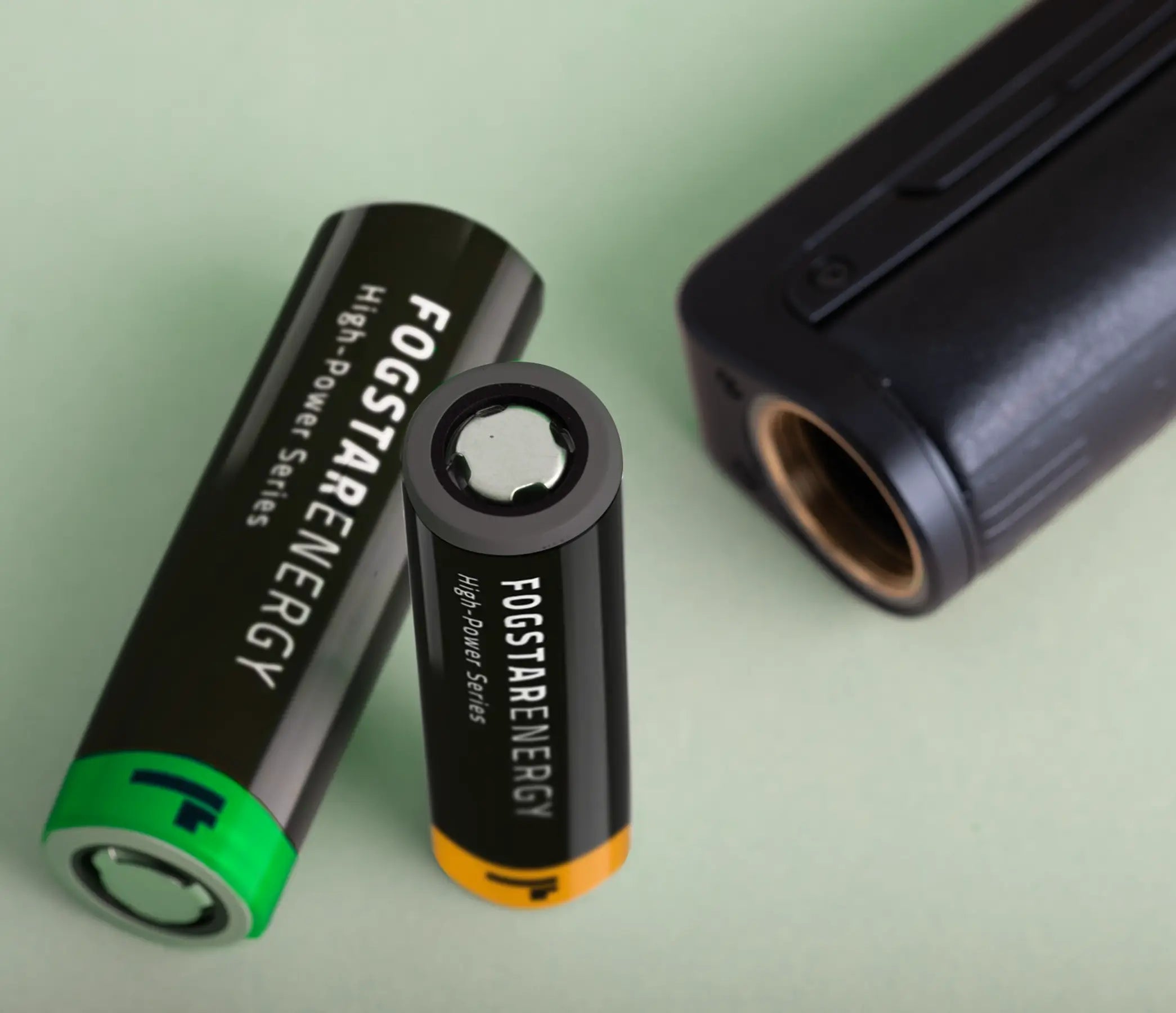 External 21700 and 18650 batteries next to an open vape kit battery compartment