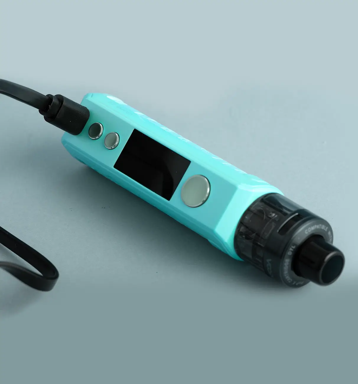 Vape kit charging with a charging cable on a blue background